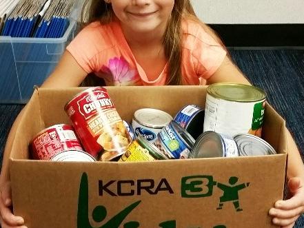 Girl holding a box of canned food